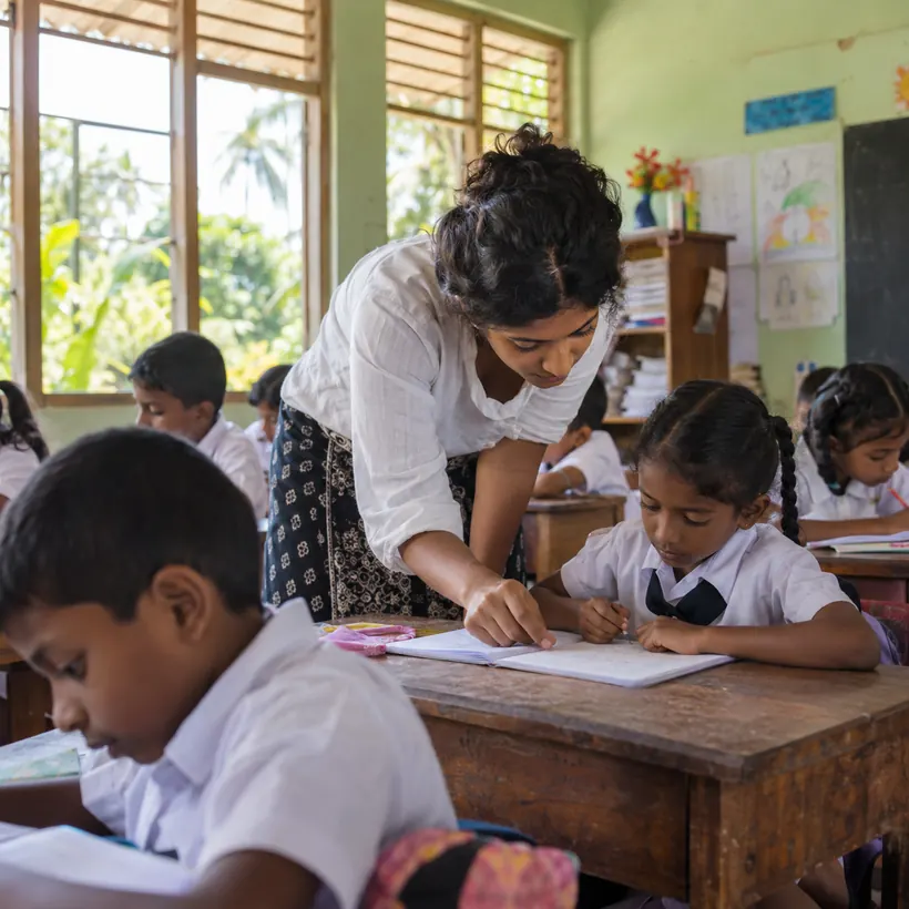 A volunteer teacher helping children in a Sri Lankan classroom